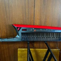 a musical instrument sitting on top of a wooden table next to a wall with wood paneling