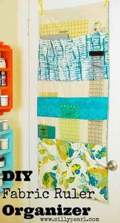 an organized fabric organizer is hanging on the wall next to a bookcase and shelves