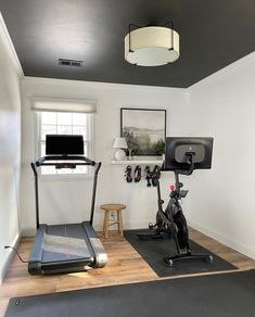 a home gym with treadmills and exercise bikes in the corner, along with a flat screen tv