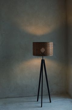 a lamp that is on top of a tripod in the middle of a room