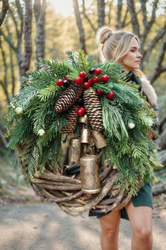 a woman carrying a christmas wreath and bells