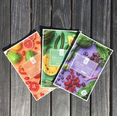 three packets of various fruits and vegetables on a wooden surface