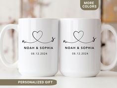 two personalized coffee mugs with the names and date printed on them, sitting next to each other