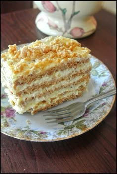 a piece of cake sitting on top of a plate next to a cup and fork