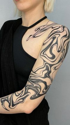 a woman with black and white tattoos on her arm