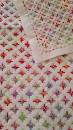 a white blanket with colorful stars on it