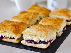 several biscuits and jelly sandwiches on a black plate