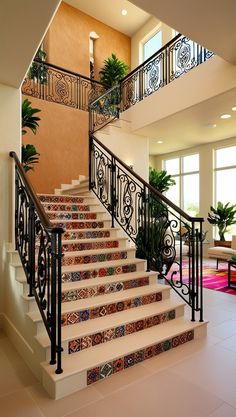 the stairs are decorated with colorful tiles and wrought iron railings, along with potted plants