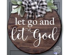 a wooden sign that says let go and let god with a bow hanging on it