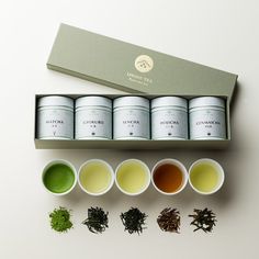 four cups filled with different types of green tea next to each other on a white surface