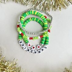 Add this set to your holiday wardrobe this year! This set of 4 is Christmas inspired and makes a great gift! Grinch Bracelet Ideas, New Years Bracelets, Cup Charms, Clay Bead Necklace, Holiday Bracelets, Beads Pattern, Diy Beaded Bracelets