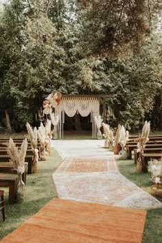 an outdoor ceremony setup with chairs and rugs