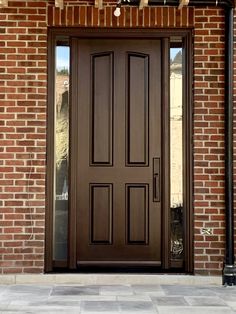 a brown front door on a brick building with two sidelights above the glass doors