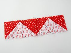 three red and white triangles on a white surface with polka dotty fabric in the middle