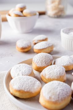 powdered sugar covered donuts on a plate next to bowls of oatmeal