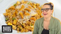 a woman with glasses is smiling next to a plate of food that includes rice and vegetables