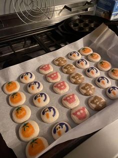 there are many decorated cookies sitting on the baking sheet in front of the stove top