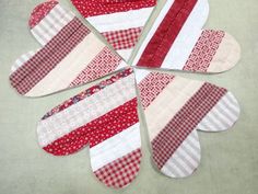 four pieces of red and white quilted fabric laid out in the shape of a flower