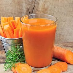 carrots are next to a glass of orange juice and some cut up carrots