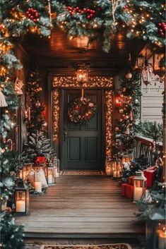 a porch decorated for christmas with candles, wreaths and garland on the front door