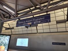 an airport sign is hanging from the ceiling