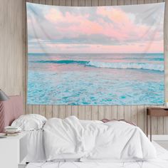 an ocean scene tapestry hanging on the wall above a bed