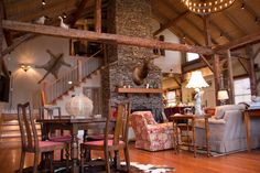 a living room filled with furniture and a fire place in the middle of a wooden floor