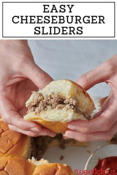 two hands are holding a hamburger slider