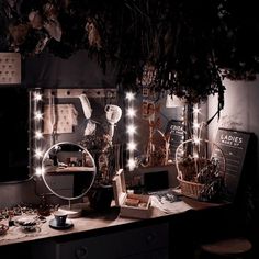 a desk with some lights on it and a mirror in the corner next to it