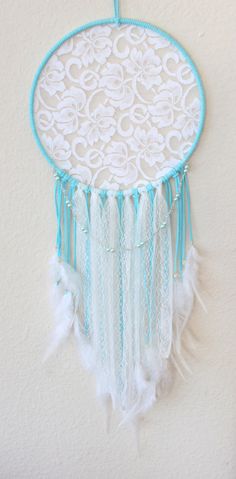 a white and blue dream catcher hanging on the wall