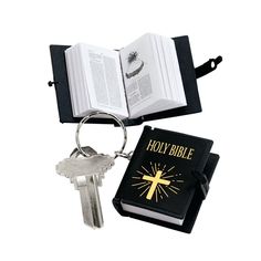 an open bible and keychain with a book on it