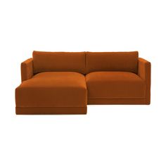 an orange sectional sofa sitting on top of a white floor next to a brown ottoman