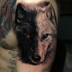 a close up of a man's arm with a wolf tattoo on his left shoulder