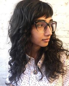 #22: Bookish Brunette Babe Glasses can present a challenge for curly hairstyles with bangs. The solution is to wear side bangs that fall an inch or so above the brows so they complement, not compete with, the frames. Unbroken length at the sides and back prevents cowlicks. Langer Pony, Hairstyle With Bangs, Wavy Bangs, Curly Bangs, Cute Styles, Hair With Bangs, Long Bangs