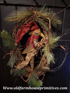 an old fashioned christmas wreath with a scarecrow in the center and pine branches around it