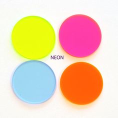 four different colors of frisbees on a white surface with the words neon