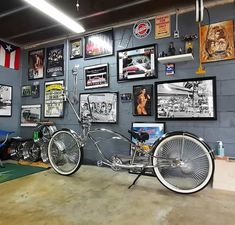 a motorcycle is parked in front of a wall full of pictures and posters on it