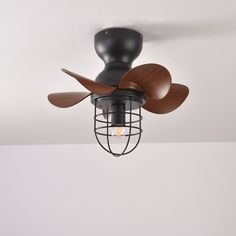 a ceiling fan with wooden blades and a caged light fixture on the top of it