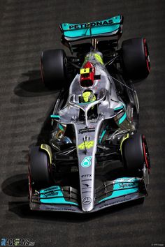 the mercedes formula car is driving down the track