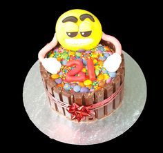 a birthday cake decorated with an emoticive smiley face and sprinkles