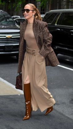 a woman walking down the street wearing brown boots