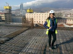 a woman standing on top of a building under construction