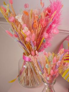 two vases filled with pink and yellow flowers