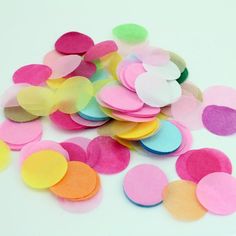 colorful confetti paper circles on a white surface with one large circle in the center