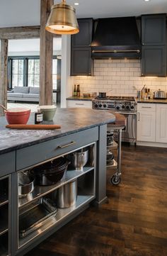 a large kitchen with an island in the middle and stainless steel appliances on both sides