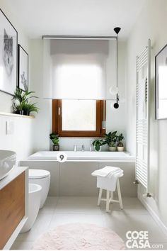 a white bathroom with a tub, toilet and sink in it's center area