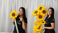 two women standing next to each other in front of a table with balloons and flowers on it