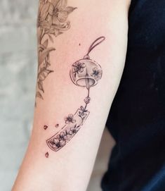 a woman's arm with a tattoo on it that has flowers and an umbrella