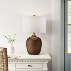 a table with a lamp and vase on it