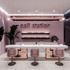 the interior of a nail salon with pink chairs and white counter tops, along with neon lights